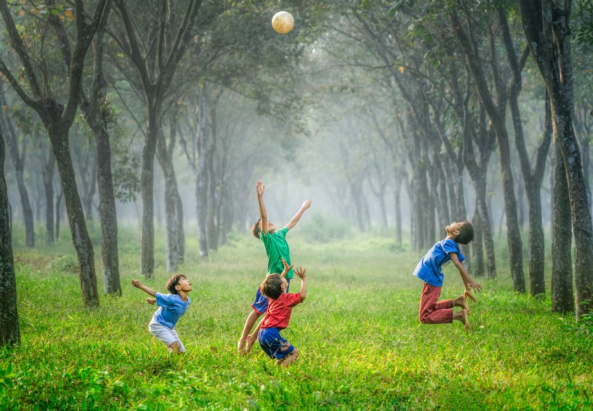 A child playing happily outdoors, fully absorbed in joyful activity